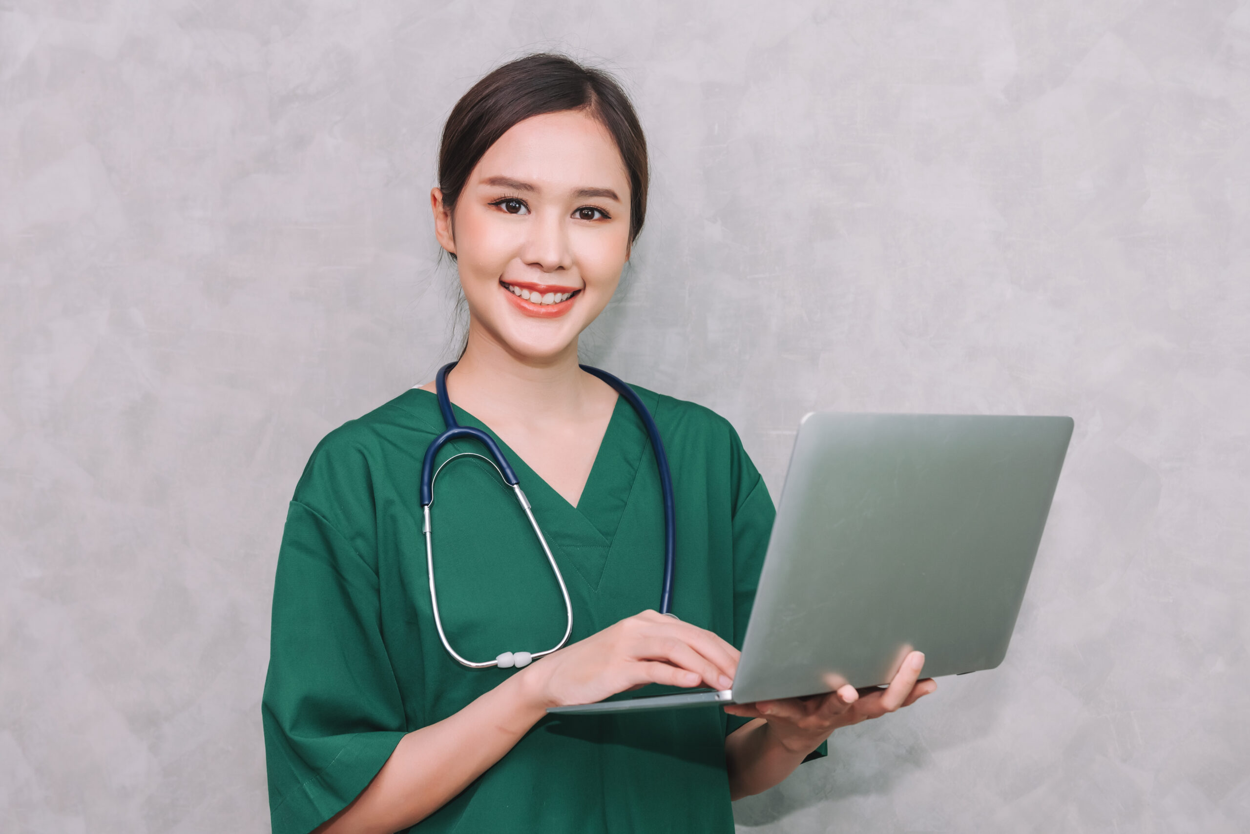 portrait beautiful asian woman doctor healthcare worker using laptop isolated grey background scaled